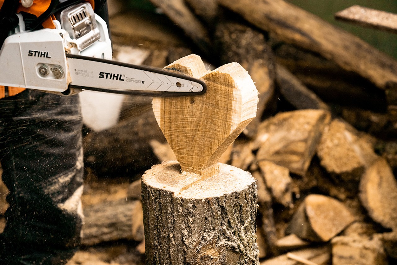 De randen van een houten hart worden gladgemaakt met een STIHL MS 170 benzinekettingzaag