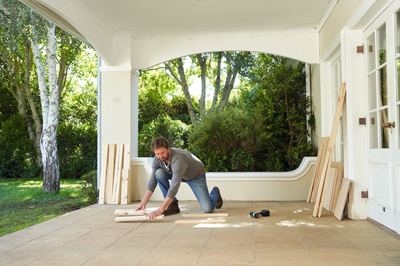 Man legt de zijstukken klaar voor een plantentafel op een veranda