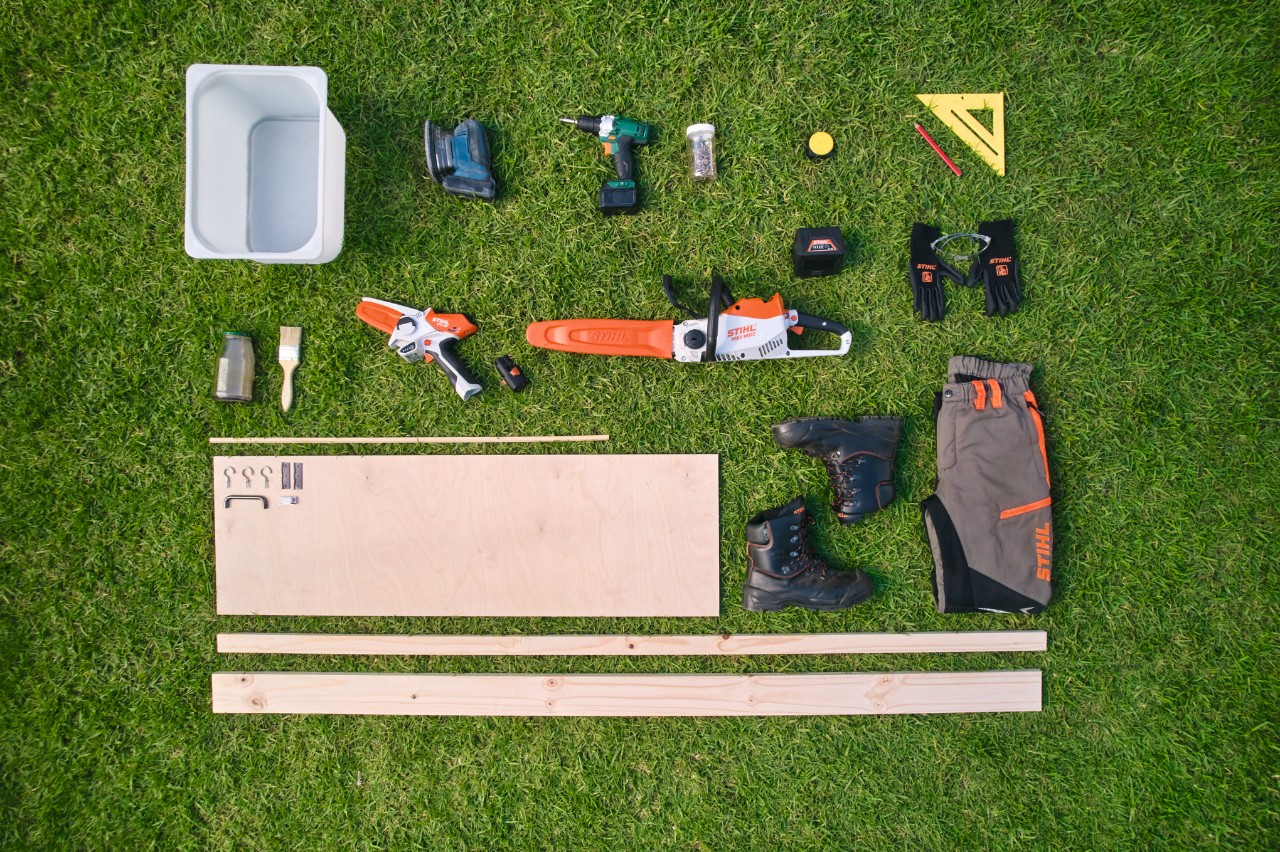 Materiaal en gereedschap voor het maken van een plantentafel op een gazon, waaronder de STIHL MSA 140 C accukettingzaag