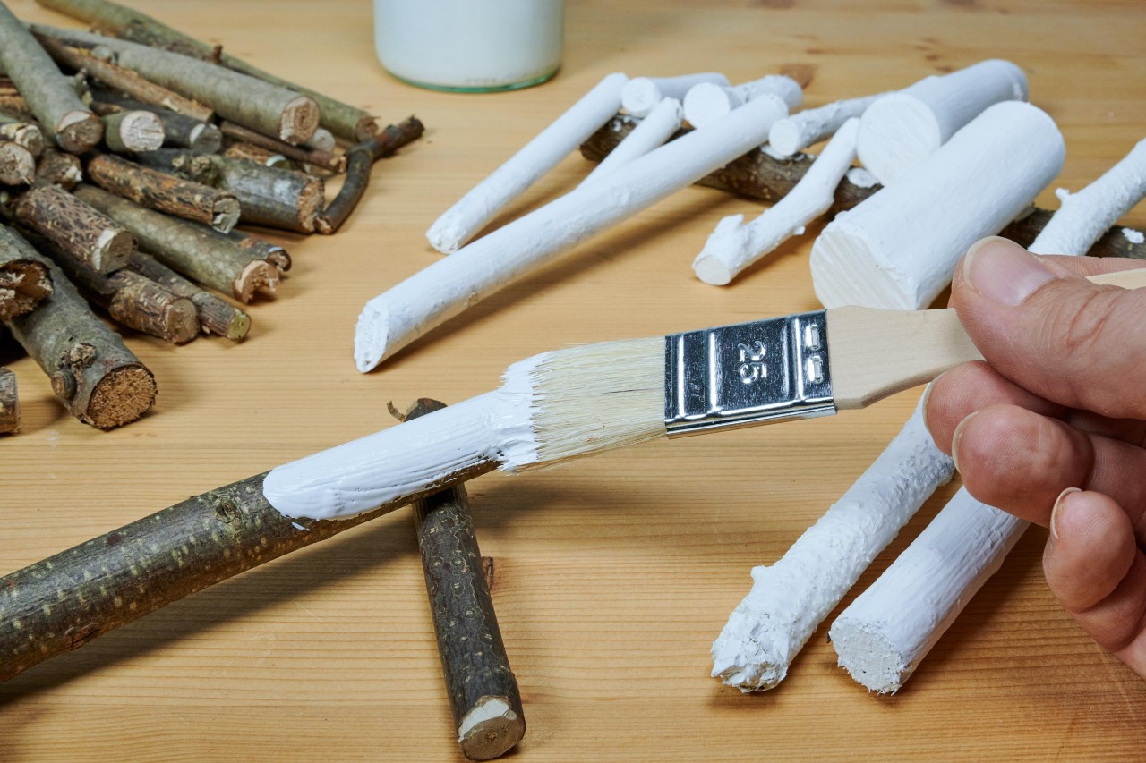 Adventskrans maken: takjes worden wit geschilderd