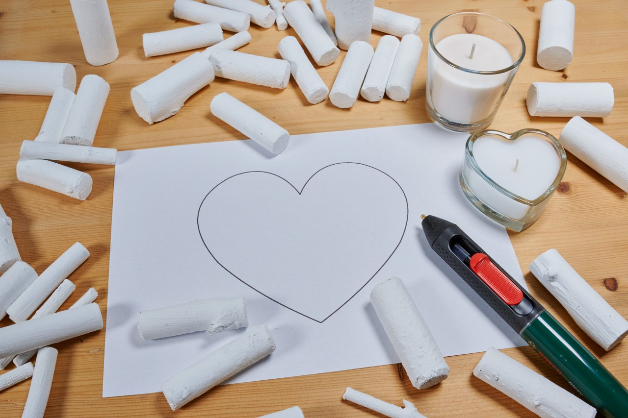 Maak een sierhart van een tak: een hartvorm op een stuk papier, met beschilderde takjes eromheen