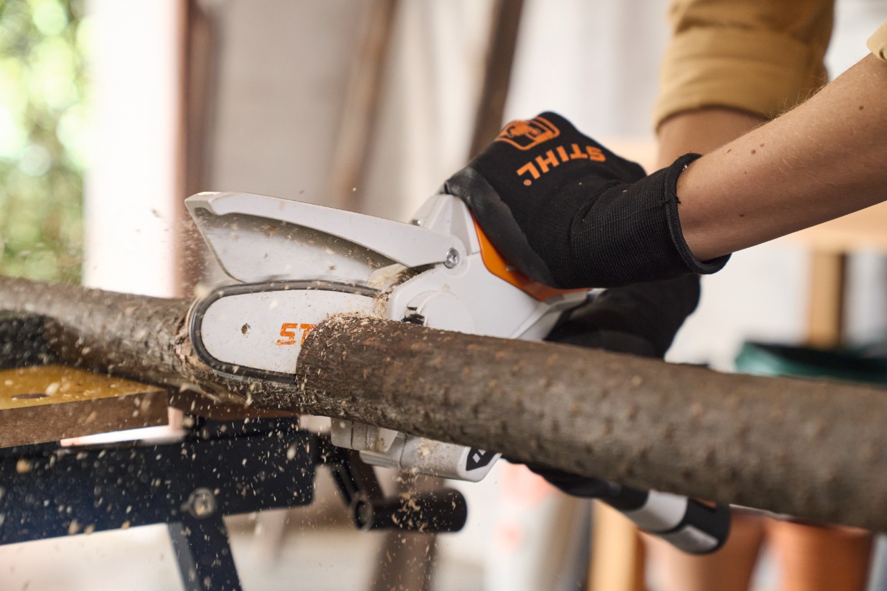 Close-up van iemand die een tak op maat maakt met de snoeischaar STIHL GTA 26