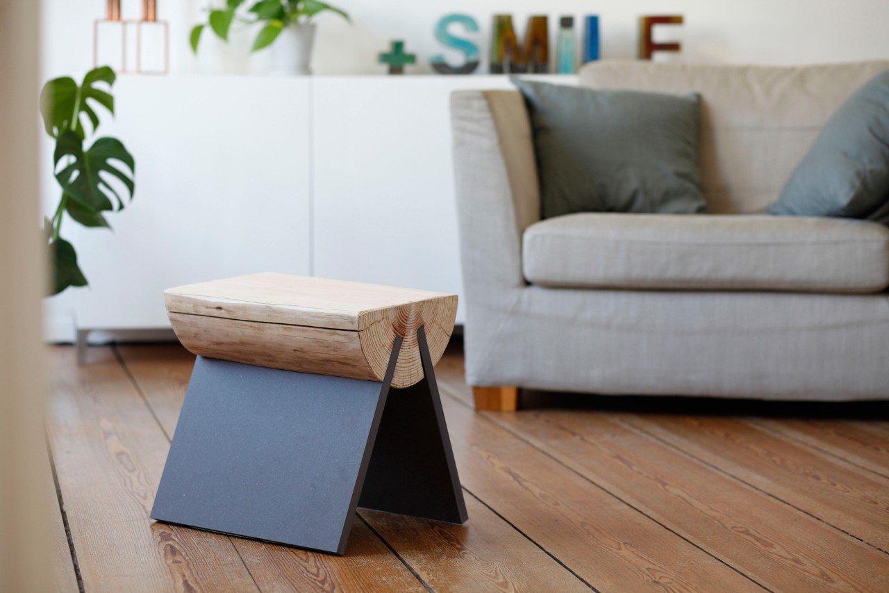 DIY-kruk van een boomstam: een afgewerkte kruk op een houten vloer in een woonkamer 