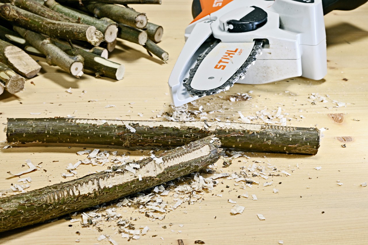 Takken met een geruwd oppervlak, erachter een STIHL GTA 26 accusnoeizaag