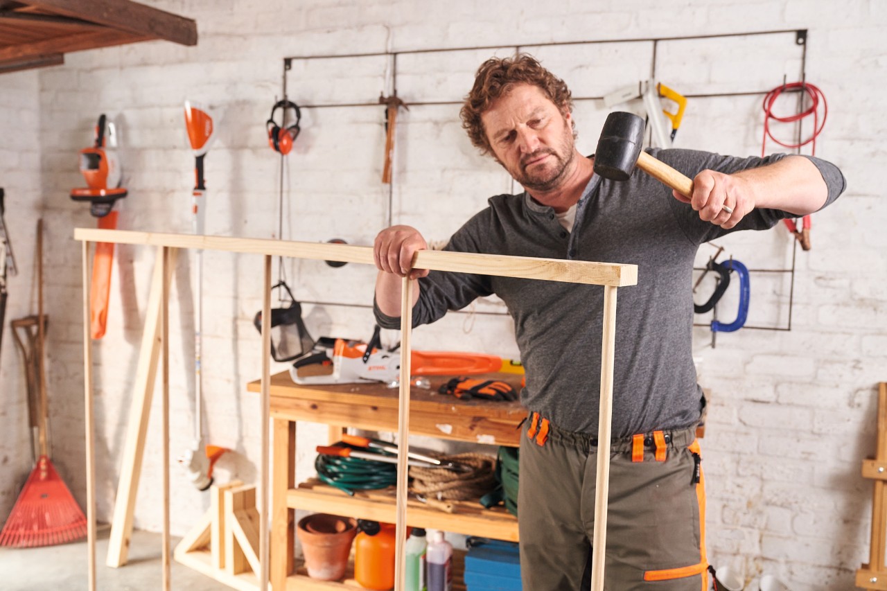 Man bouwt zelf een houten bescherming tegen inkijk en verbindt daarvoor de framebalken