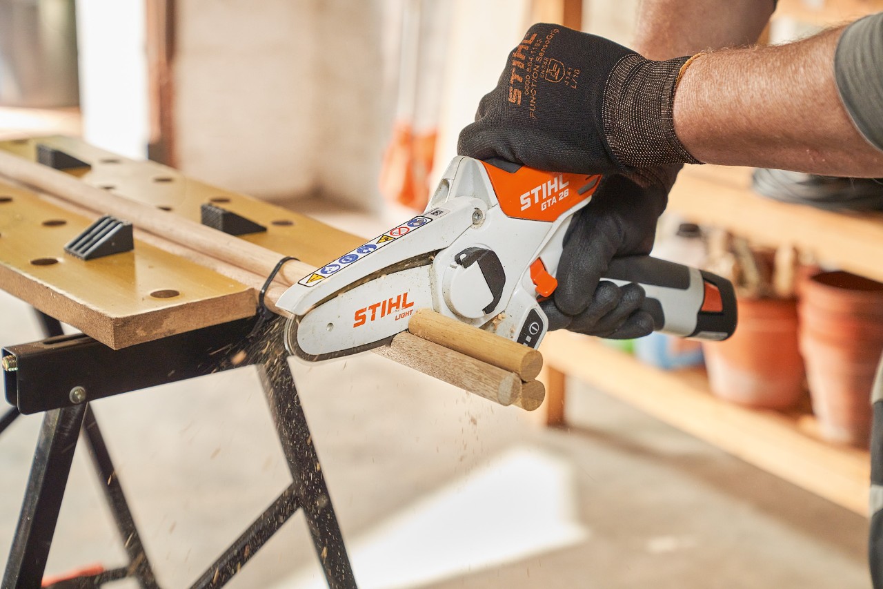 Een man zaagt ronde stokjes met de STIHL GTA 26 accusnoeizaag