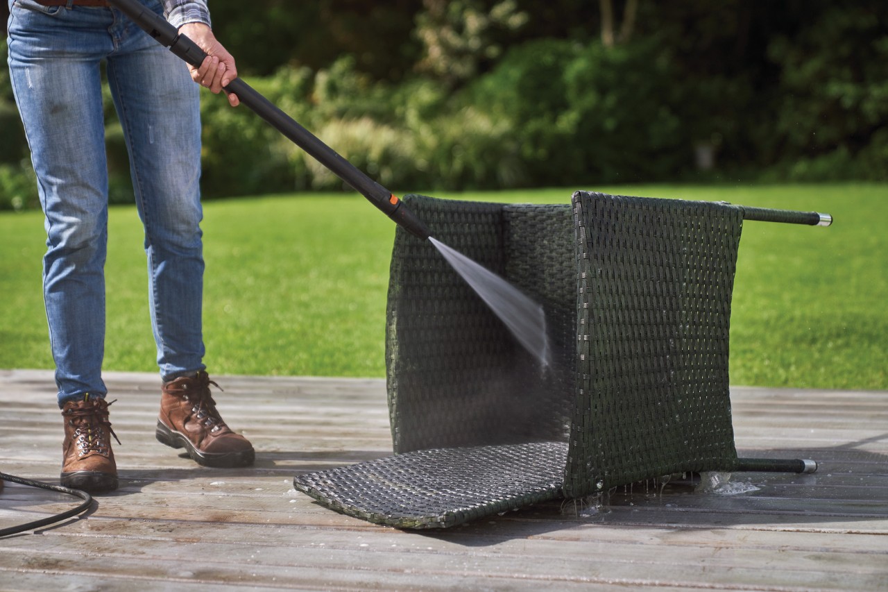 Een rotan stoel die op de rug ligt en wordt gereinigd met een STIHL RE 130 Plus hogedrukreiniger