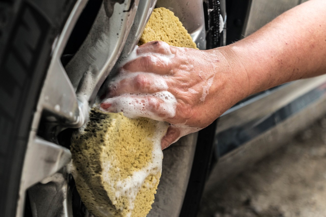 Close-up van autovelgen die met een spons worden gereinigd