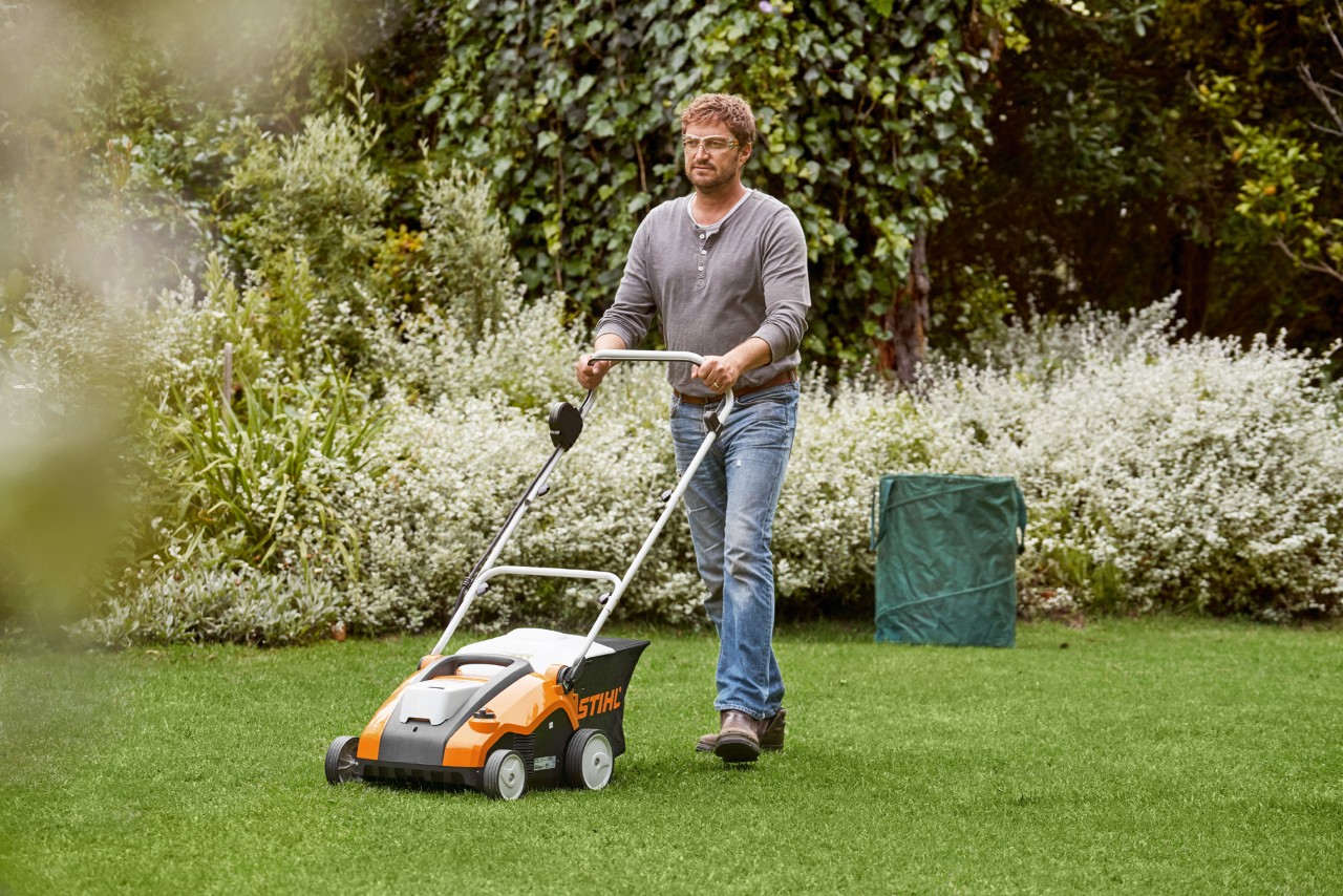Man verticuteert groen gazon met een STIHL RLA 240 accuverticuteermachine