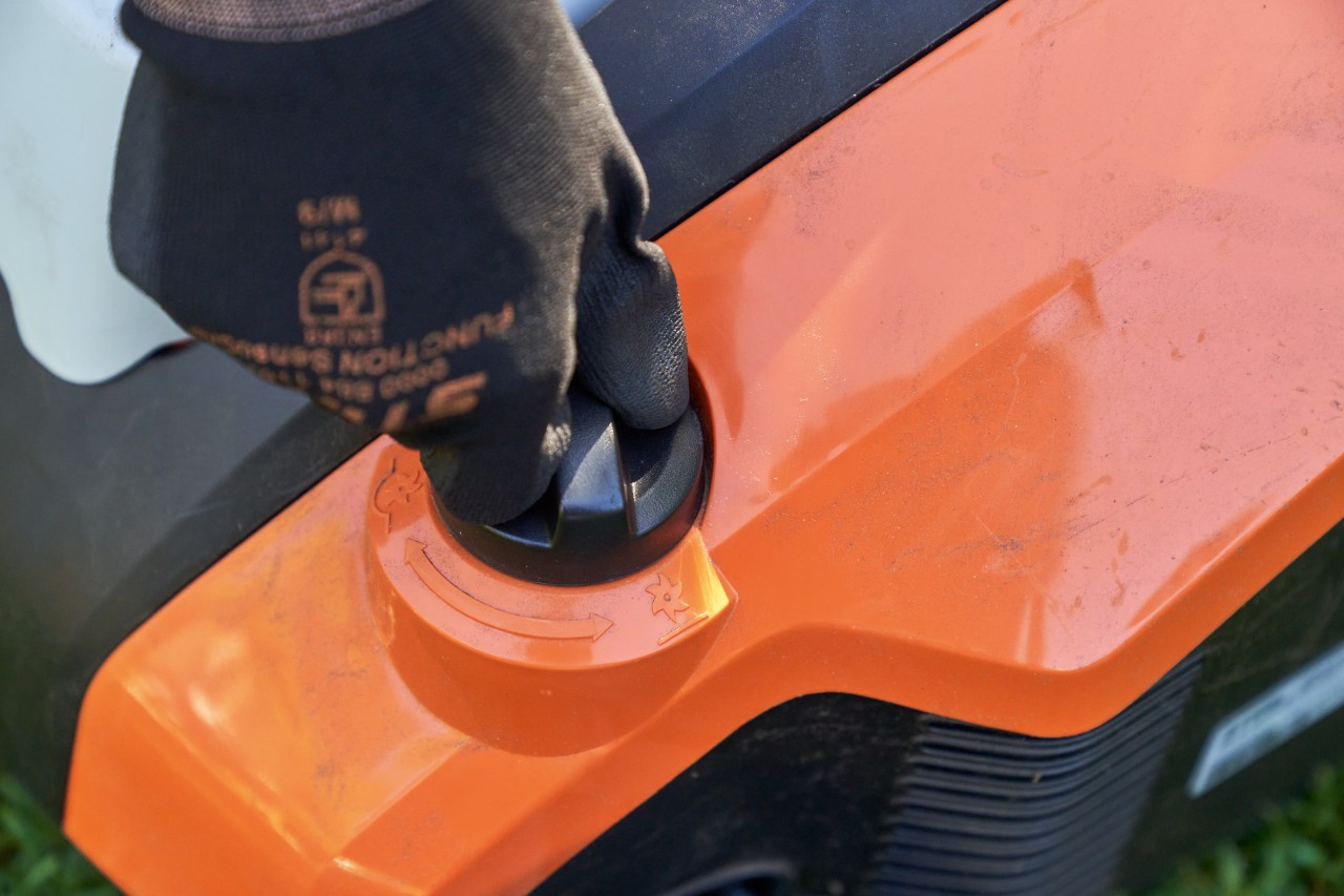 Close-up: hand met STIHL FUNCTION SENSOTOUCH werkhandschoen draait aan knop van de STIHL RLA 240 accuverticuteermachine.