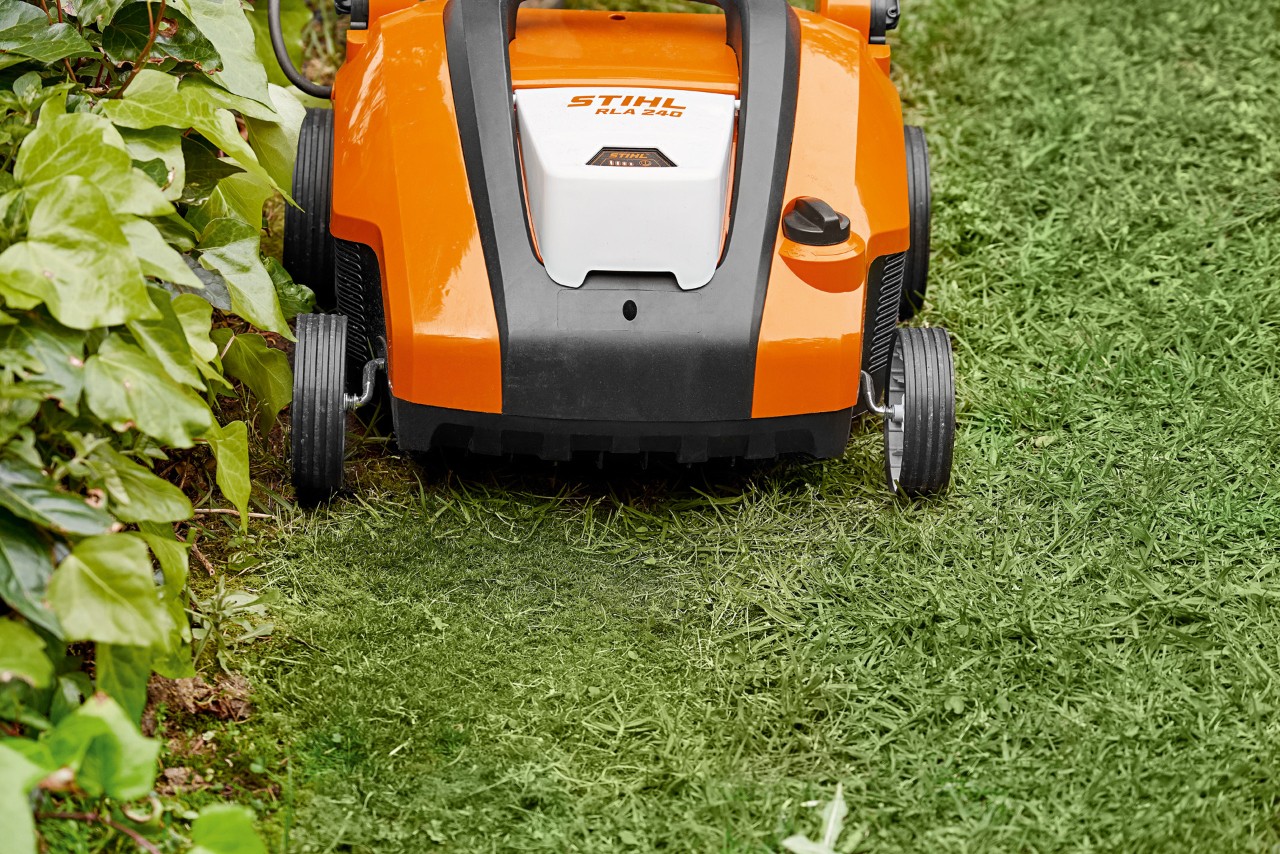 Close-up van de STIHL accuverticuteermachine RLA 240 vóór het gazon wordt bezand