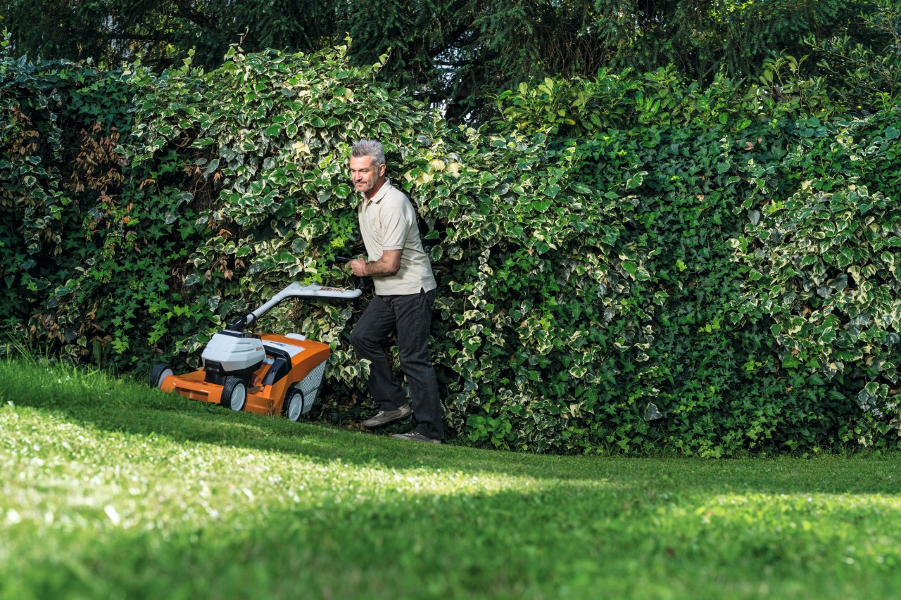 Een man maait op een helling met een STIHL RMA 448 TC accugrasmaaier  