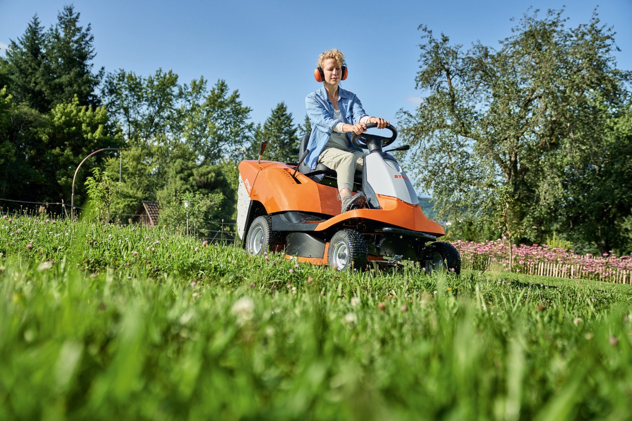 Een vrouw maait op een helling met een STIHL RT 4082 zitmaaier 