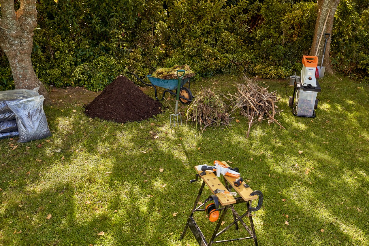 Materiaal in een tuin om een hoge plantenbak te vullen: STIHL GHE 140 elektrische hakselaar, gehakseld groen en compost