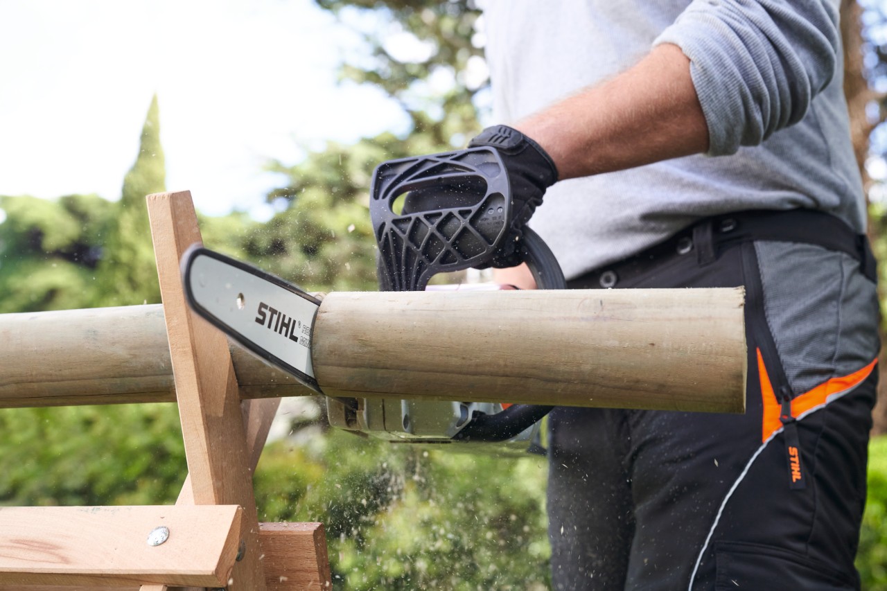 Een man zaagt een tak door met een STIHL accu-kettingzaag