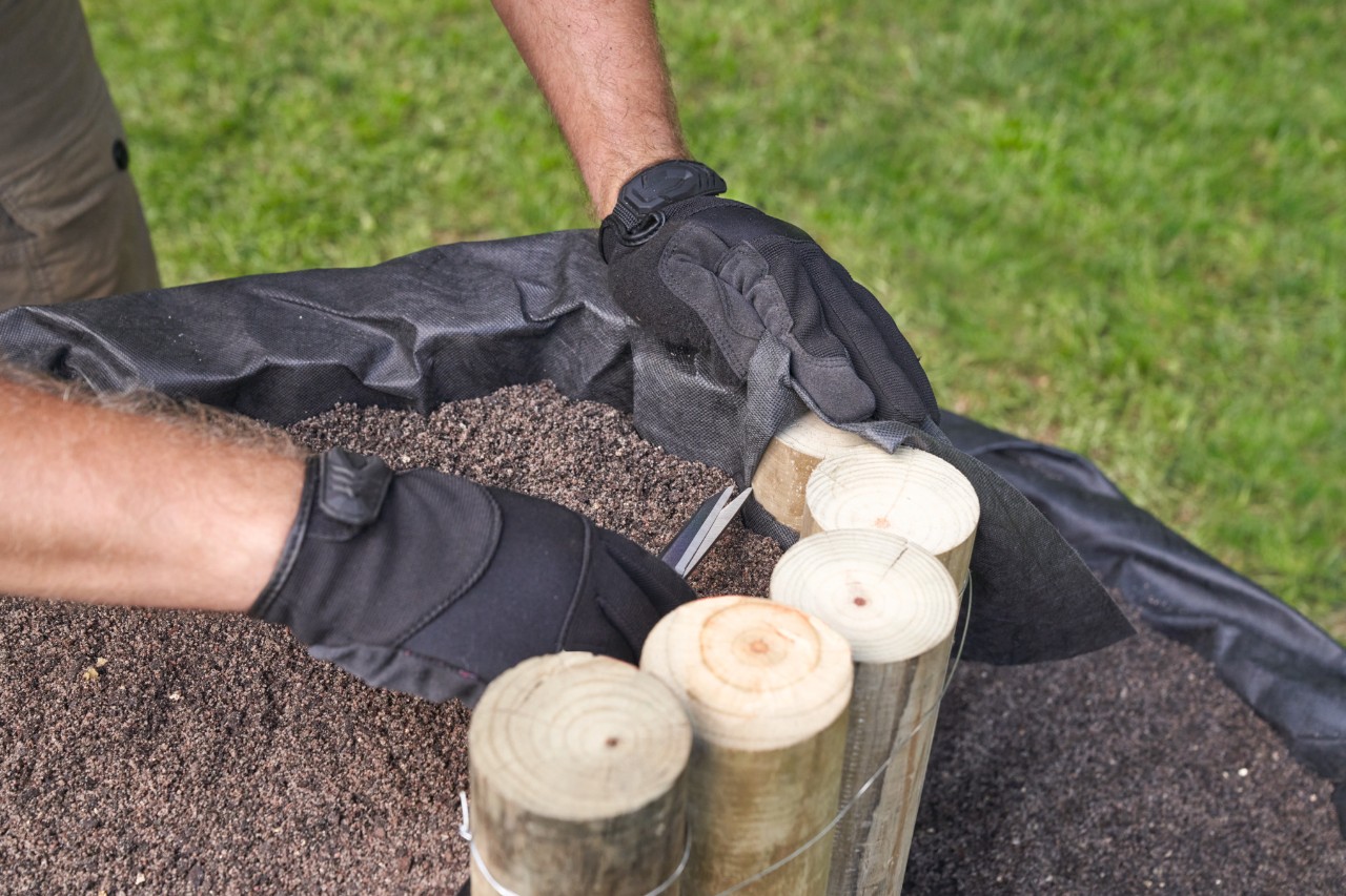Close-up van iemand die de uitstekende drainage met een schaar bijknipt 