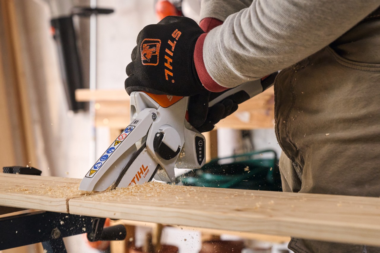 Een man zaagt houten planken met een STIHL GTA 26 accusnoeizaag