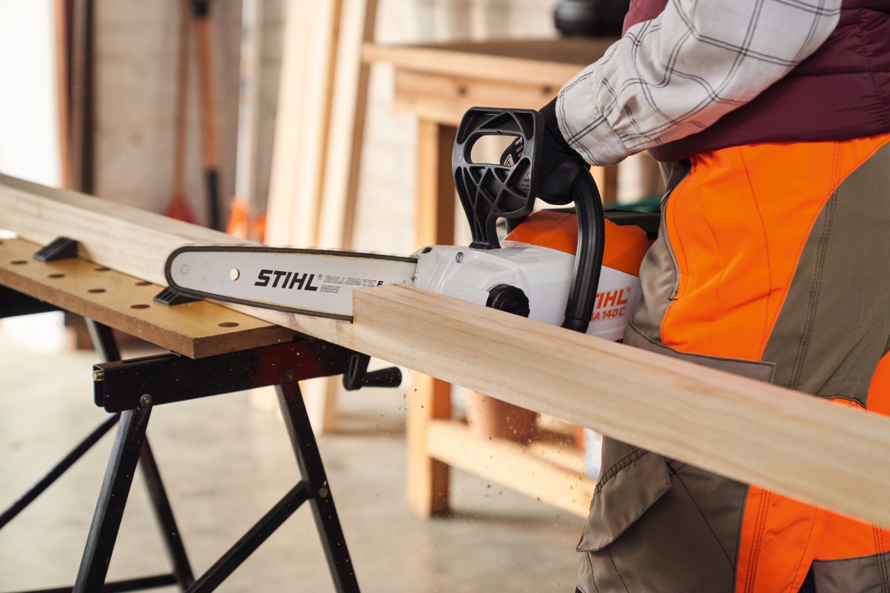 Close-up van hoe de STIHL MSA 140 accukettingzaag een balk afzaagt