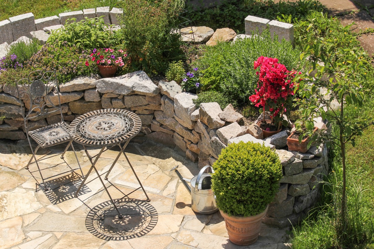 Mediterrane tuin op een helling met terras en tuinmeubelen
